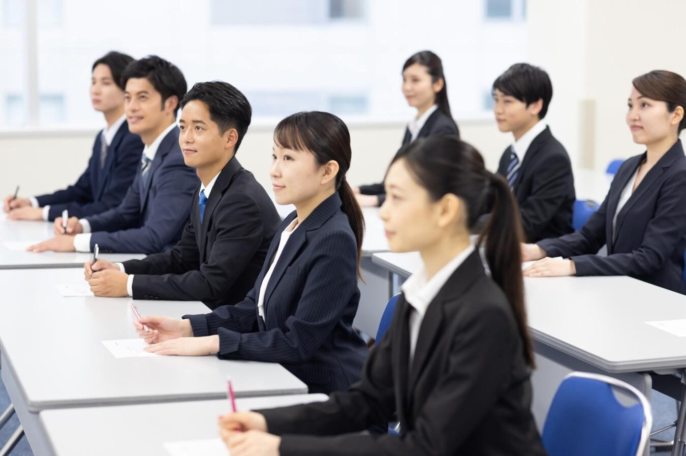 横に並んで座るスーツの男女4人