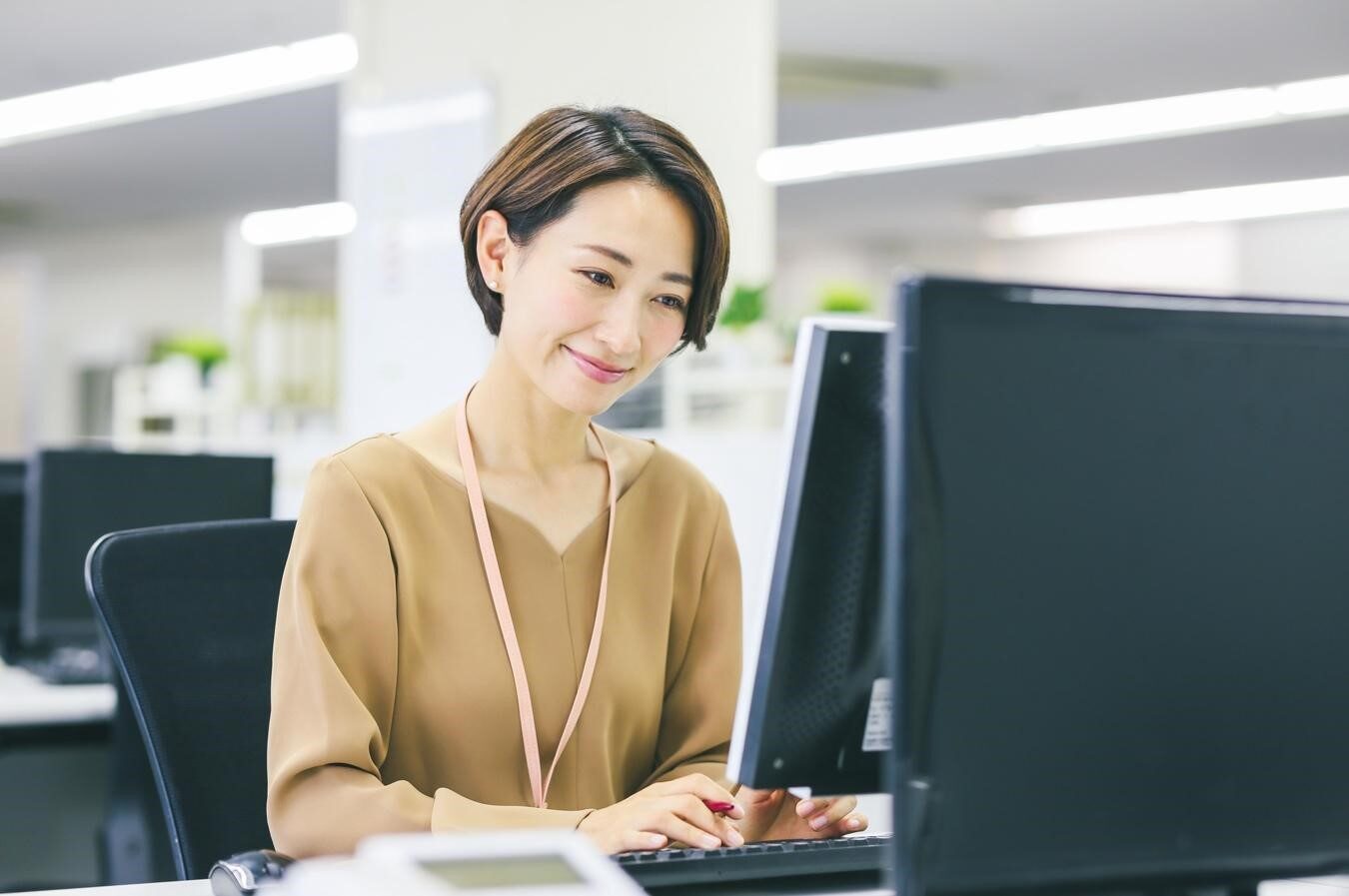 笑顔でパソコンを操作する女性